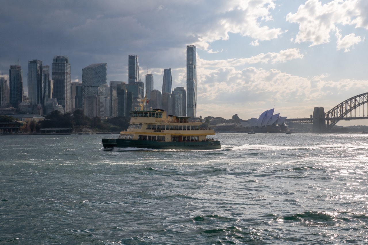 A Sydney ferry crossing the harbour with the city skyline behind it