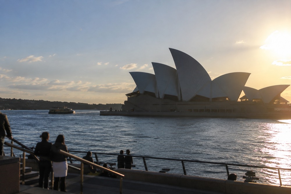 The broad steps and sail roofs of the Sydney Opera House seen from the harbour forecourt
