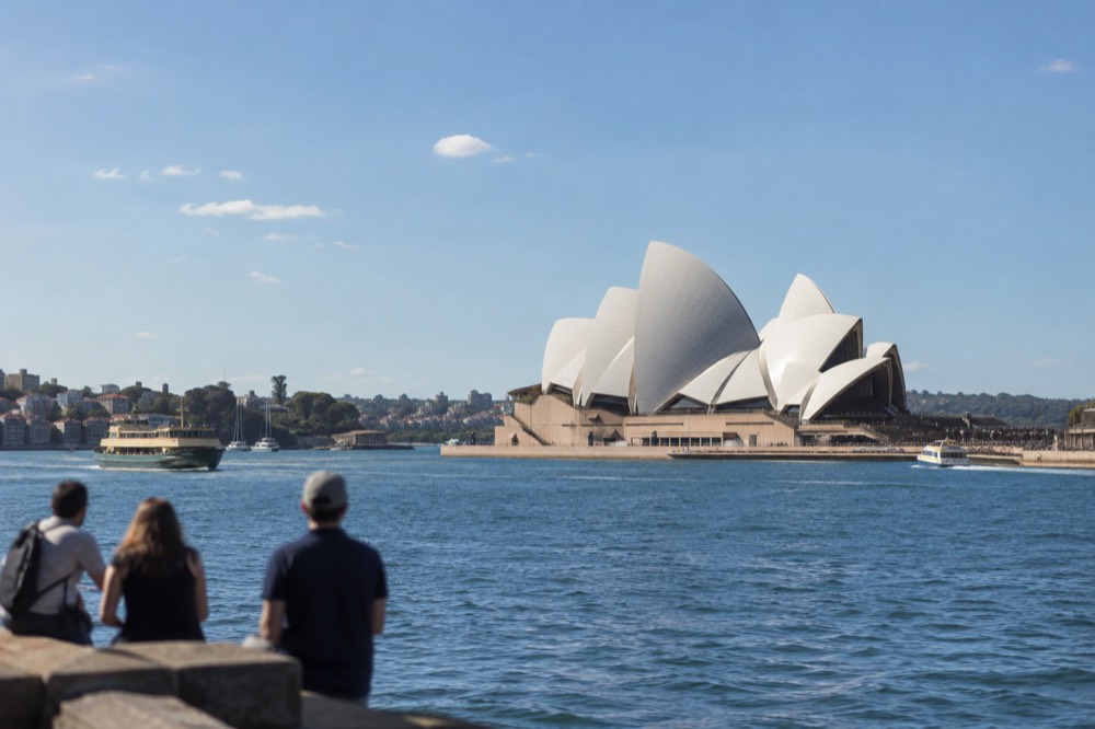 The white sails of the Sydney Opera House seen across Circular Quay harbour water