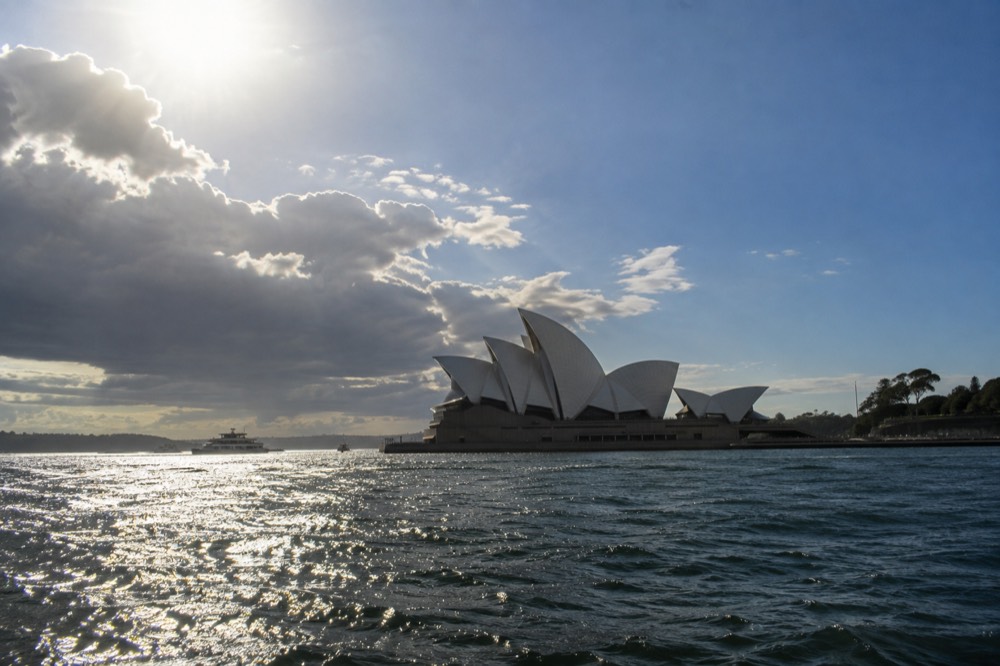 Sunlight falling across the curved white sail roofline of the Sydney Opera House