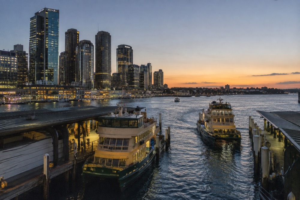 Sydney ferries moored at Circular Quay with the city skyline behind them