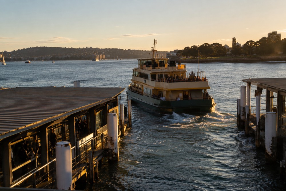 Ferry departing a Sydney wharf on a clear afternoon