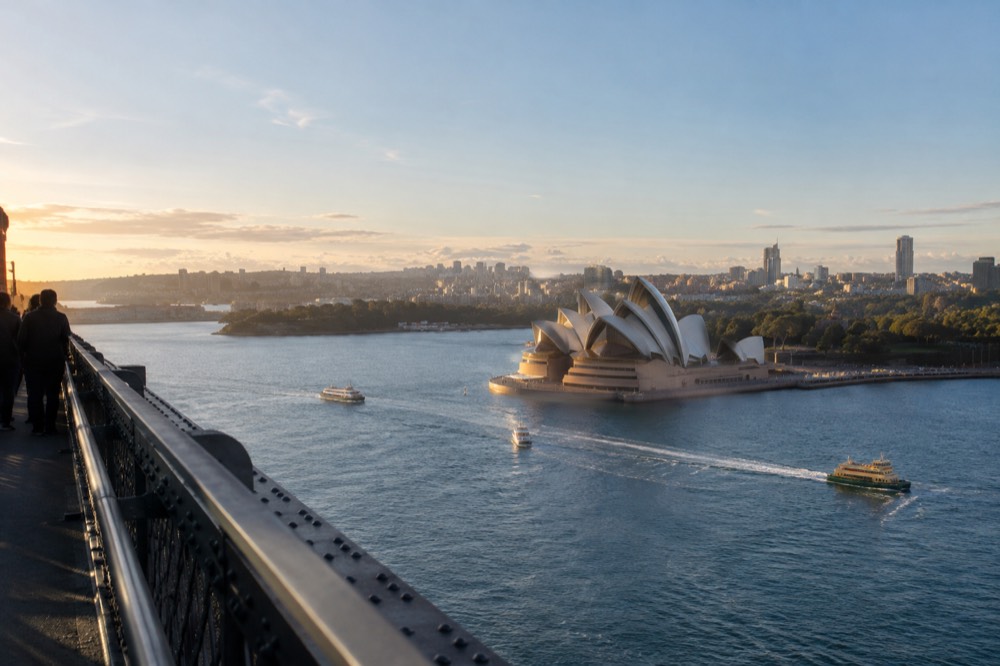 A view across Sydney Harbour from the upper arch of the bridge with the Opera House white sails below
