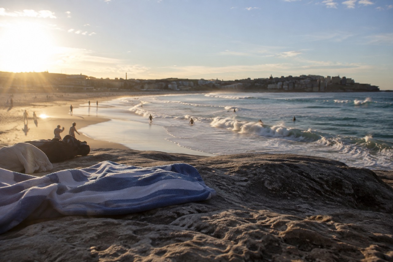 Bondi Beach curving between sandstone headlands with rolling surf along the shore