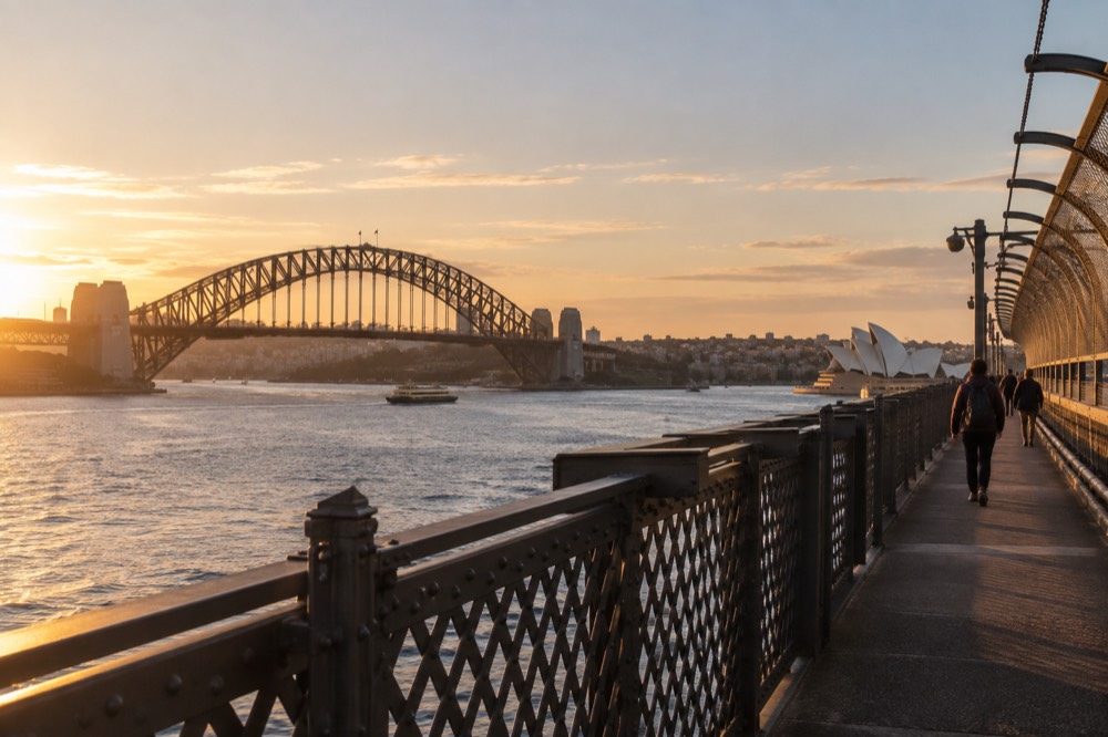 The Sydney Harbour Bridge walkway with the Opera House and Circular Quay visible across the water