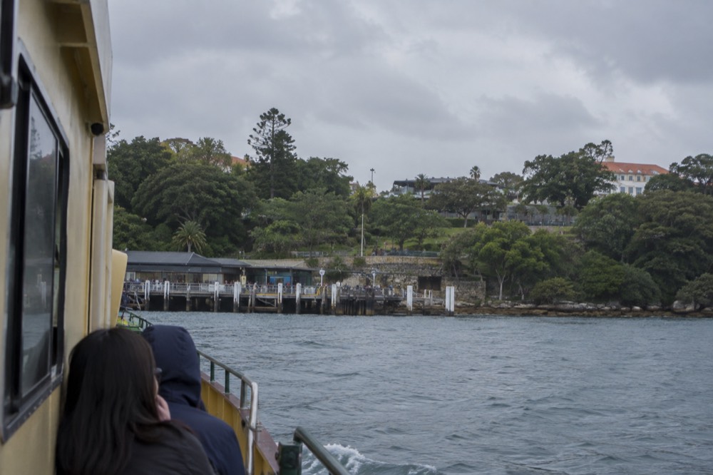 Ferry approaching a wharf with the zoo hillside rising above the water