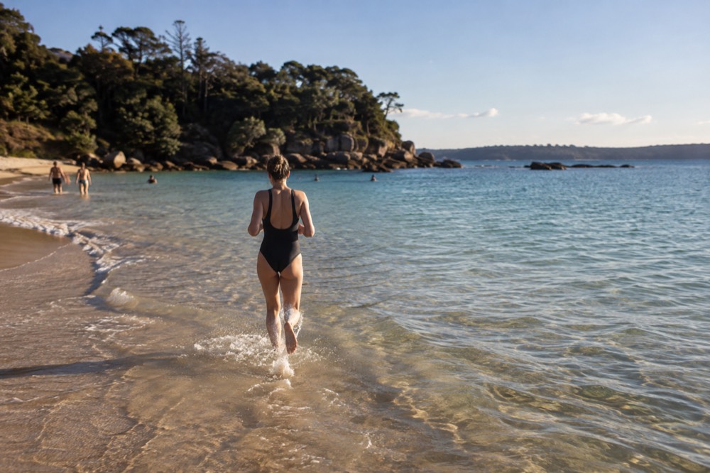 Shallow clear water over sand at Shelly Beach with rocky headland in the background