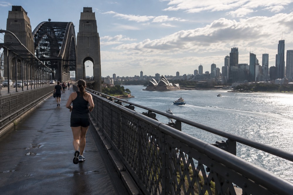 View from the northern end of the bridge toward the Opera House and city skyline across sparkling harbour water