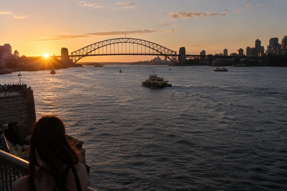 Sydney Harbour Bridge and city skyline at sunset seen from the water