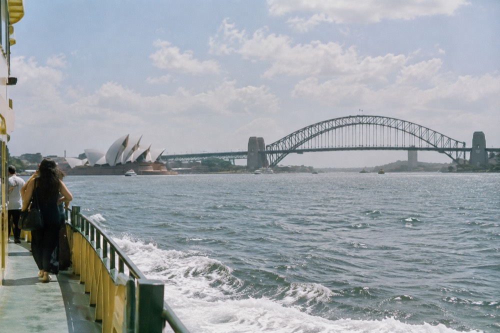 Sydney Harbour with the Opera House and Harbour Bridge seen from the water at midday