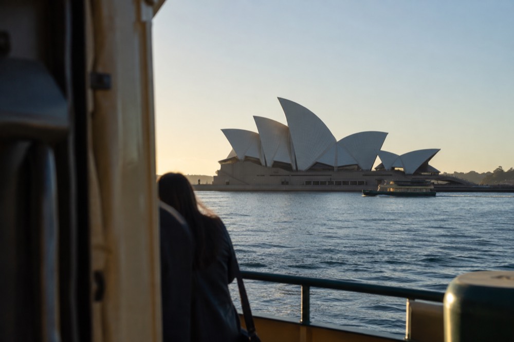 The Sydney Opera House sails against a clear sky seen from Circular Quay