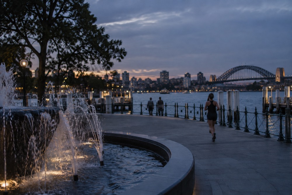 A water fountain in a Sydney park with the harbour skyline behind it