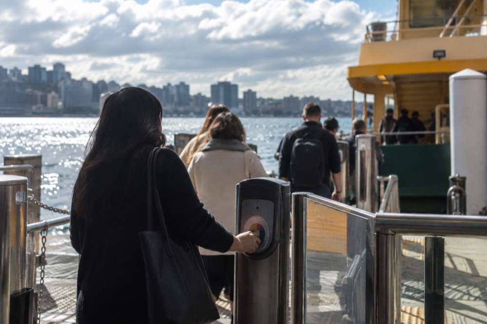 Ferry passengers tapping an Opal reader at a Circular Quay wharf gate