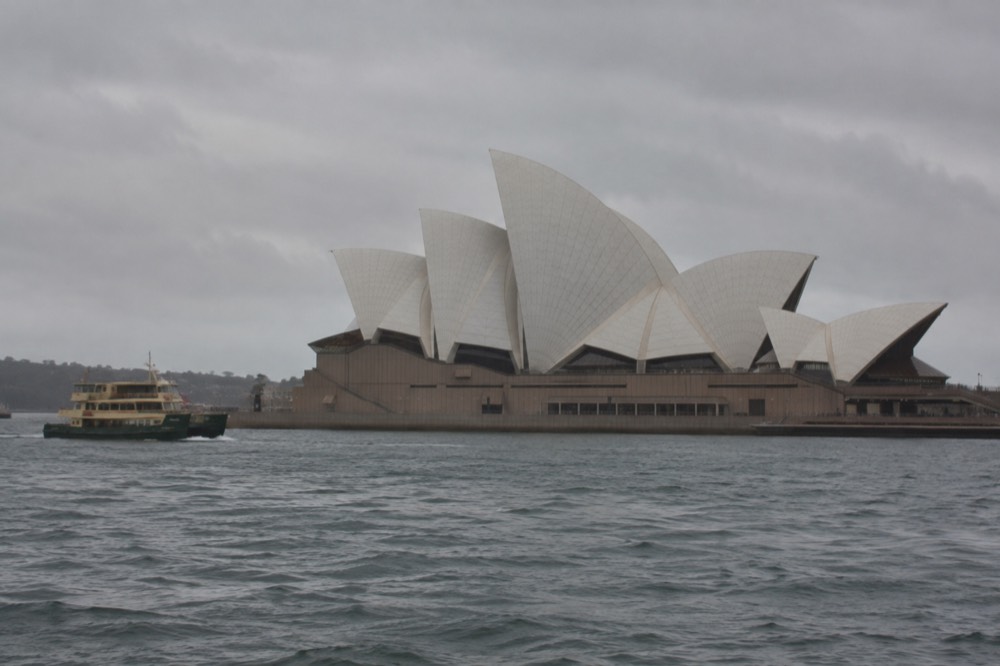The white sail roofs of the Sydney Opera House seen from the harbour water