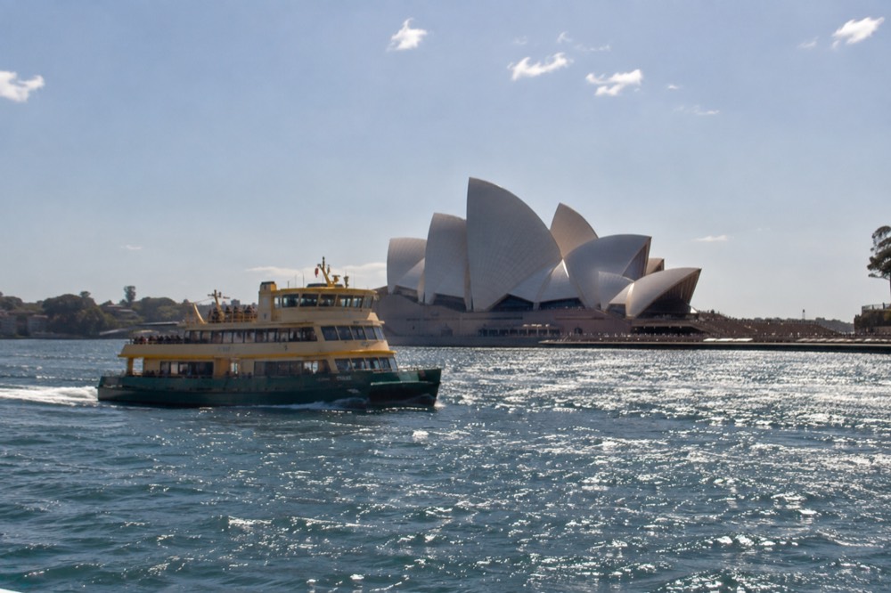 A ferry passing the Sydney Opera House sails on sparkling harbour water