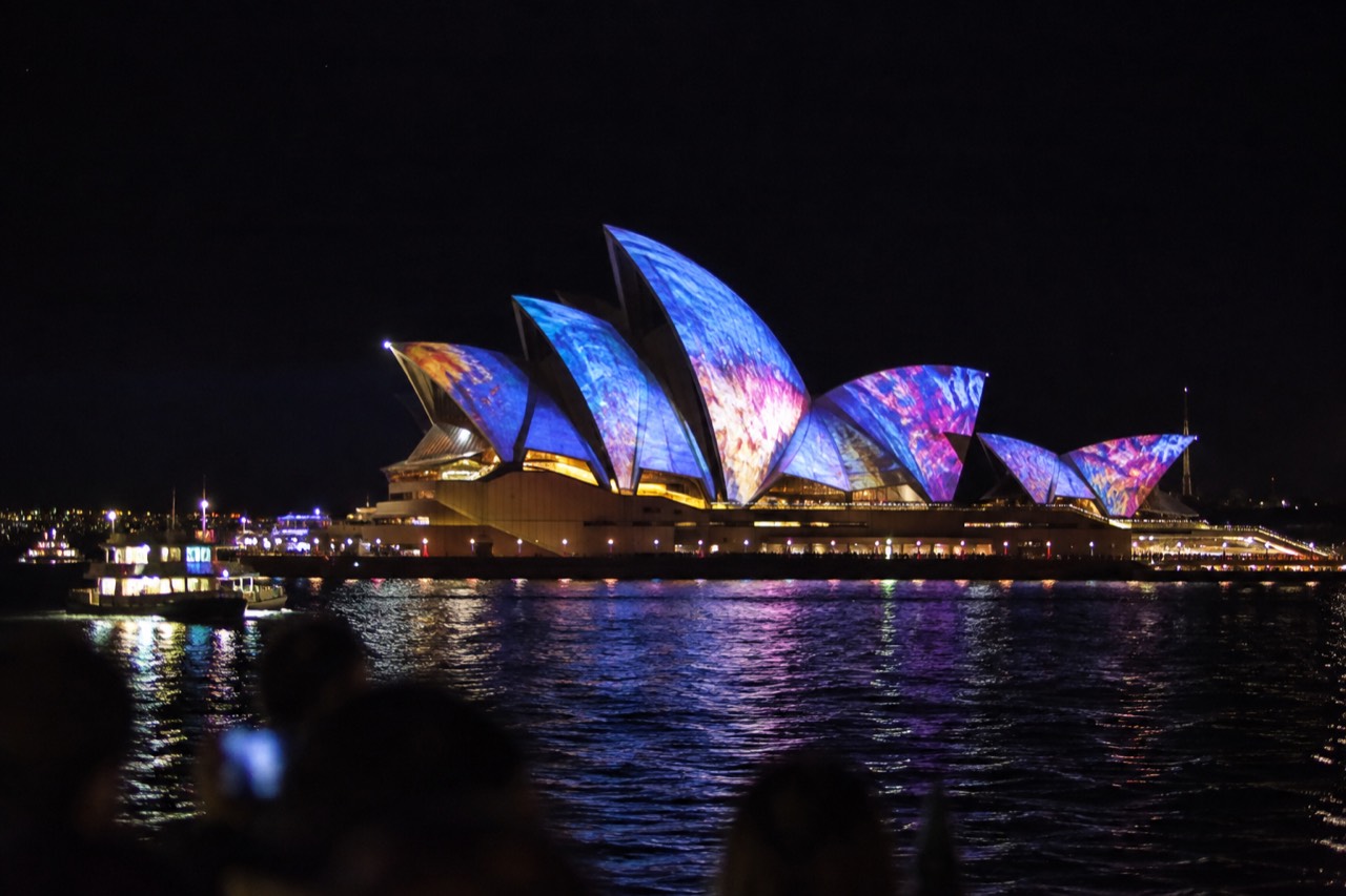 Sydney Opera House sails lit with colourful projections at night during a harbour light festival