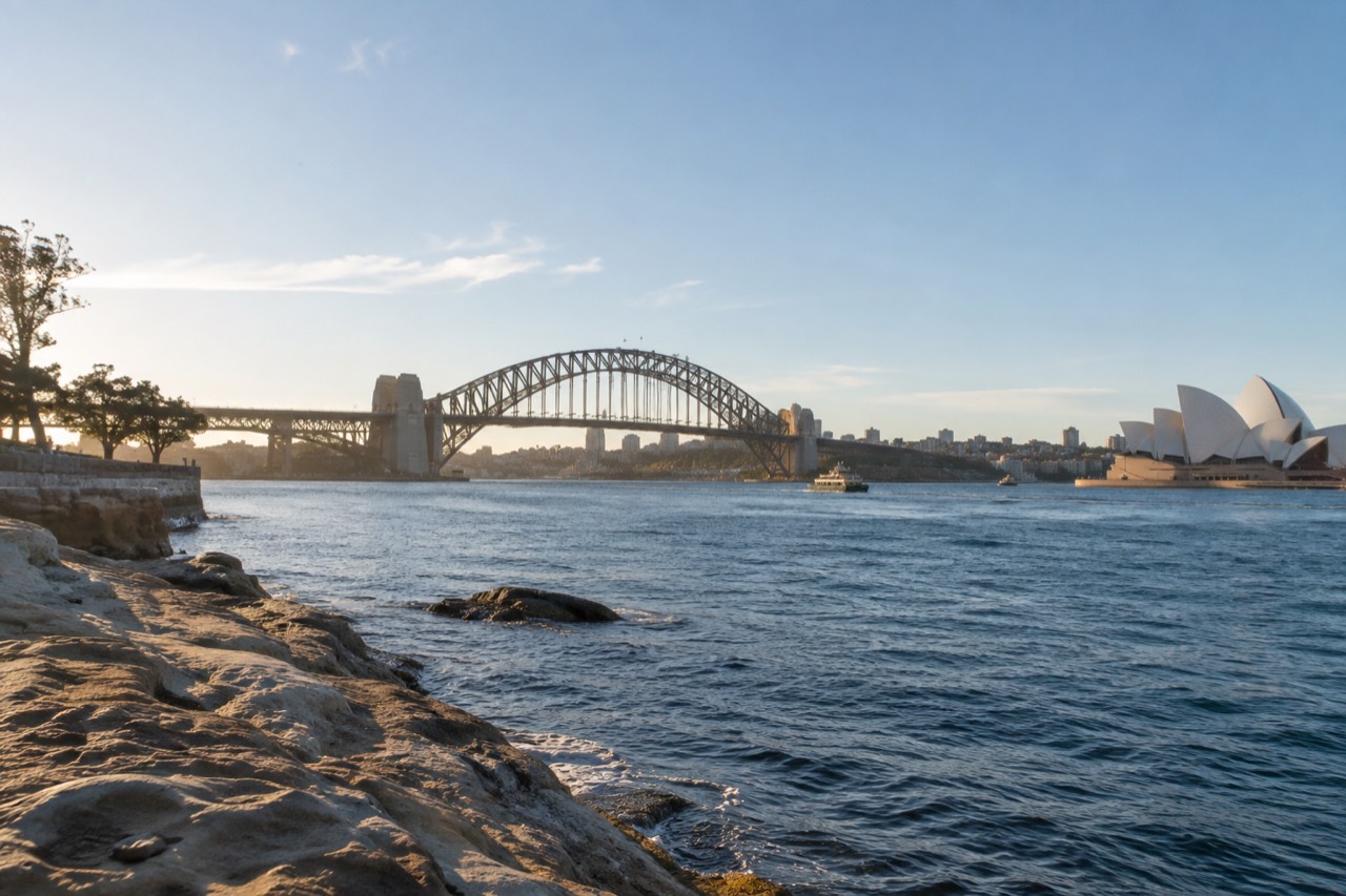 Sydney Harbour on a clear morning with the Opera House and Harbour Bridge along the shoreline
