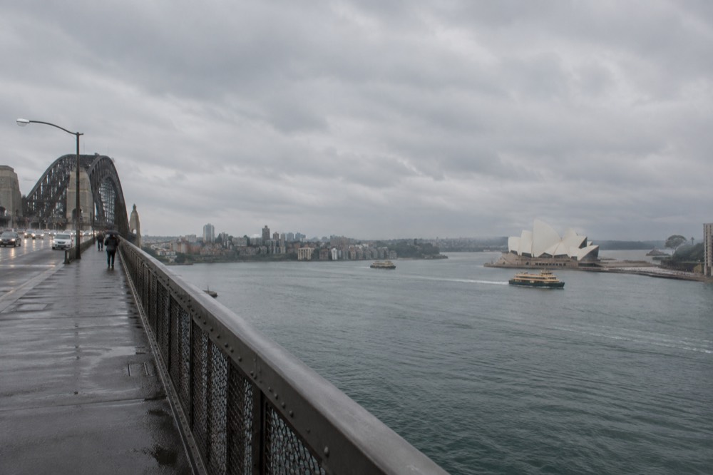 The bridge walkway with the Opera House and harbour seen from beside the roadway