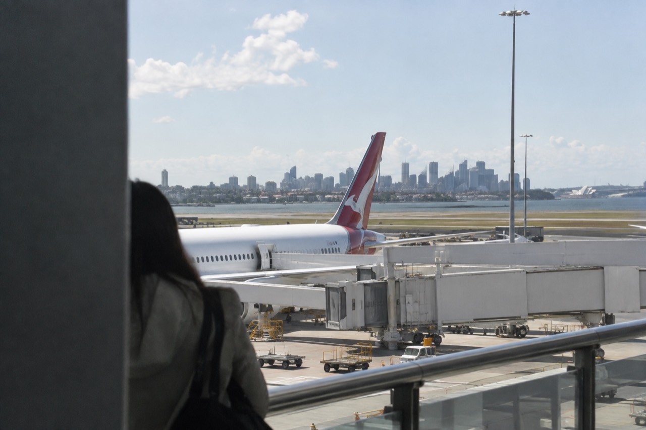 Sydney Airport terminal exterior with city skyline in the distance