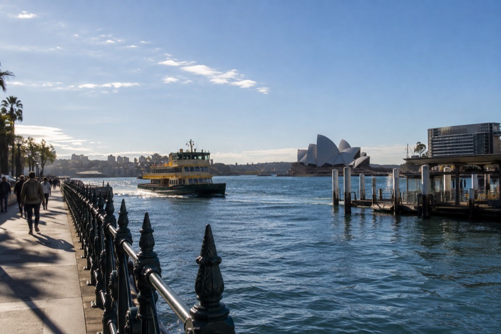 Sandstone cliffs and ocean pools along a Sydney coastal walking path on a clear morning