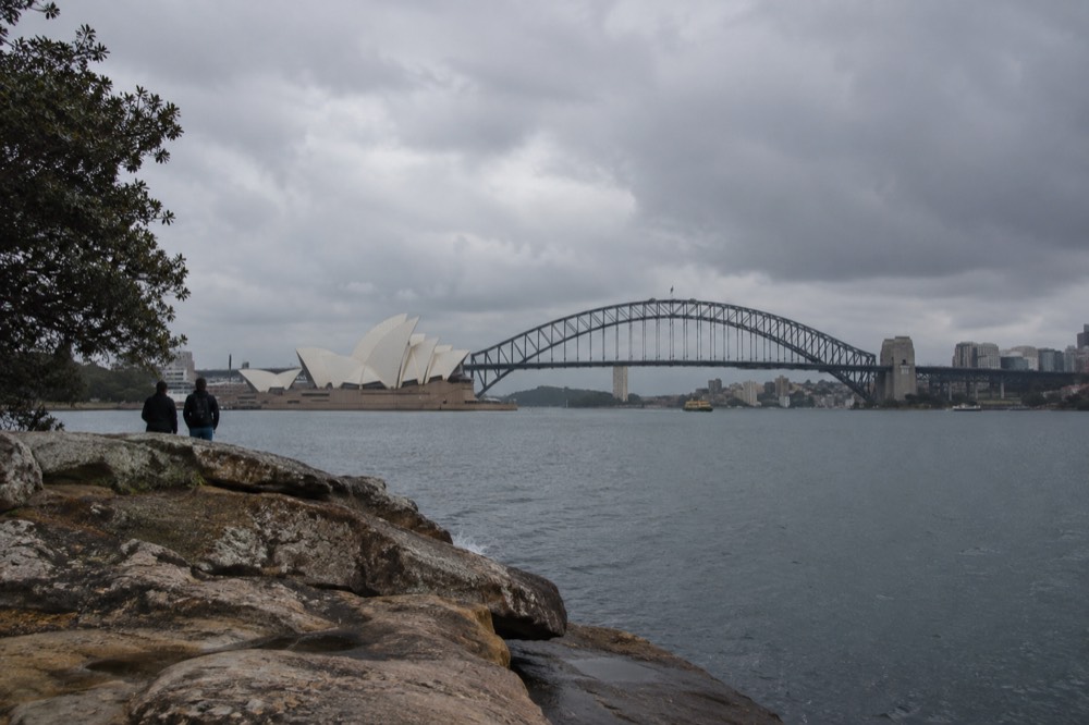 Sandstone point overlooking calm harbour water with the Opera House and Harbour Bridge in one view