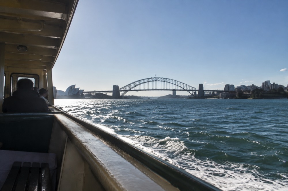 Ferry crossing Sydney Harbour with the Harbour Bridge in the background under a clear sky