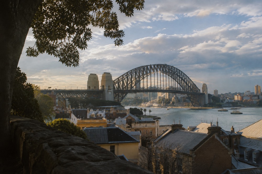 The Sydney Harbour Bridge rising above the Rocks rooftops in early morning light