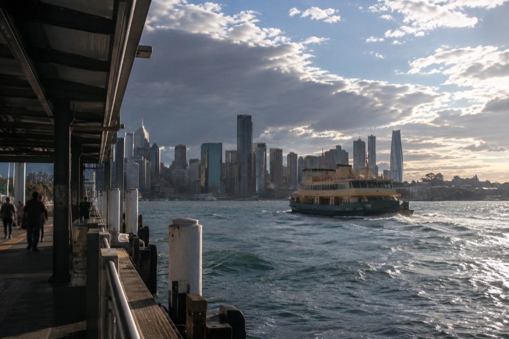 A Sydney ferry crossing the harbour towards Manly with the skyline behind