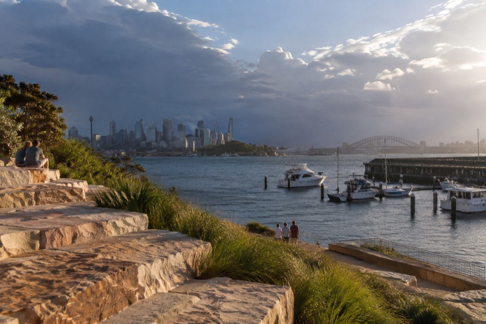 Sandstone steps and native grasses on a recontoured harbour headland above moored boats