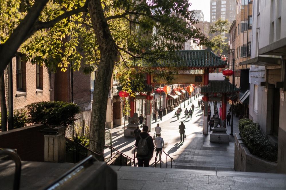 Ceremonial archway at the entrance to Dixon Street with lanterns and shop signs along the pedestrian mall