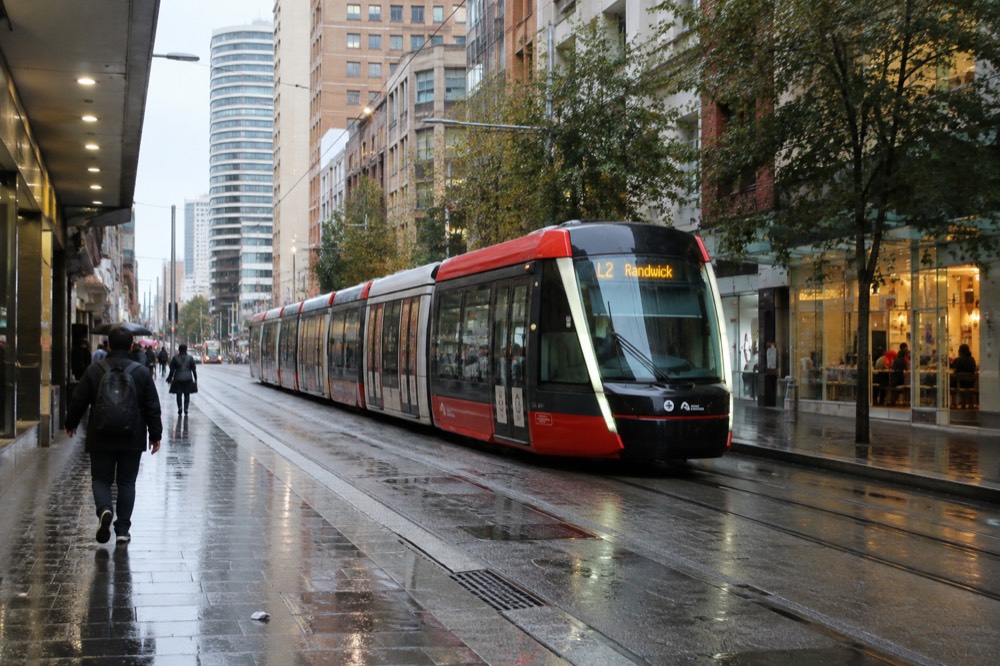 Light rail tram travelling along George Street past shopfronts near Haymarket