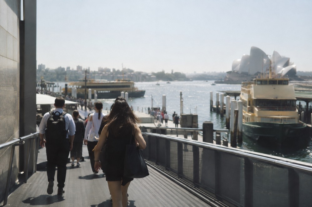 Commuters walking down the ramp from Circular Quay station towards the ferry wharves