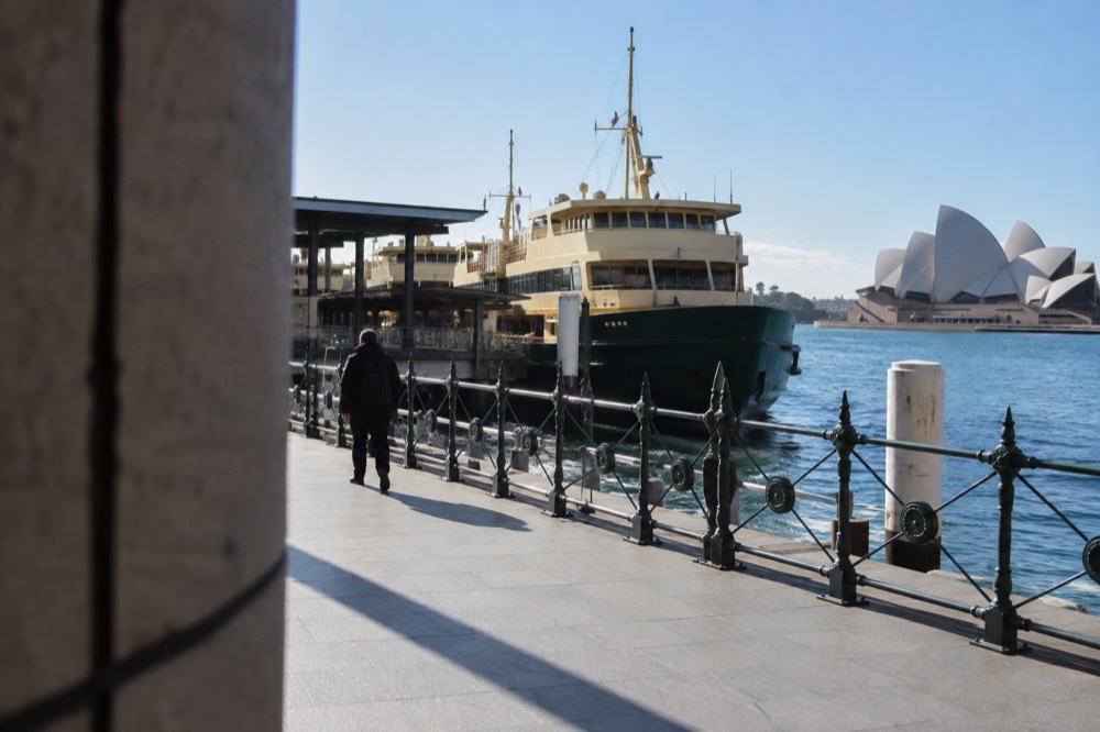 Early morning light on an almost empty Circular Quay promenade with ferries at their wharves