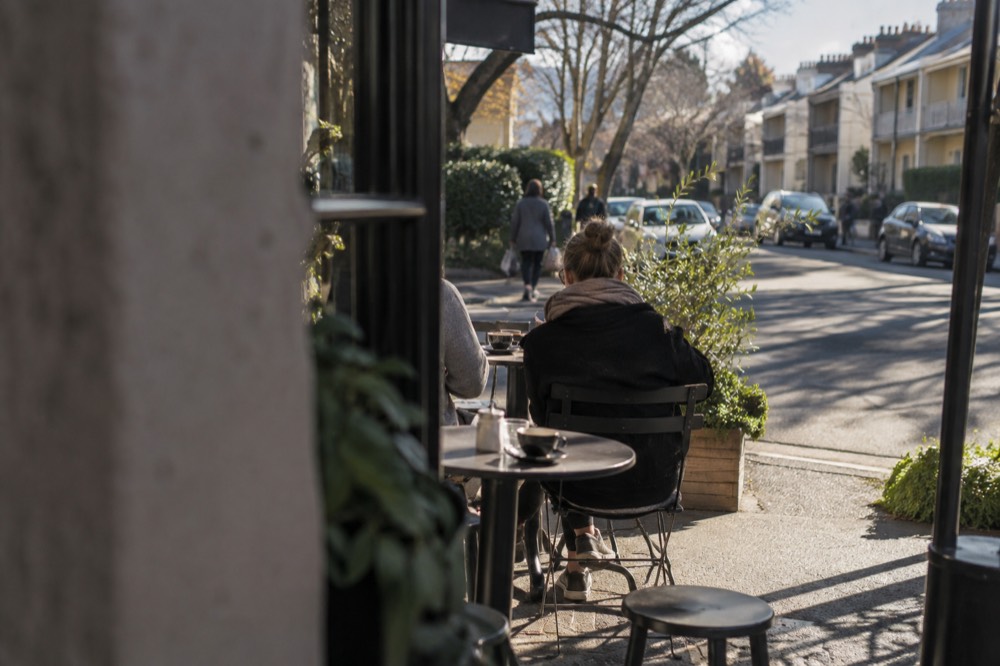 Sidewalk café tables with coffee cups on a Paddington corner