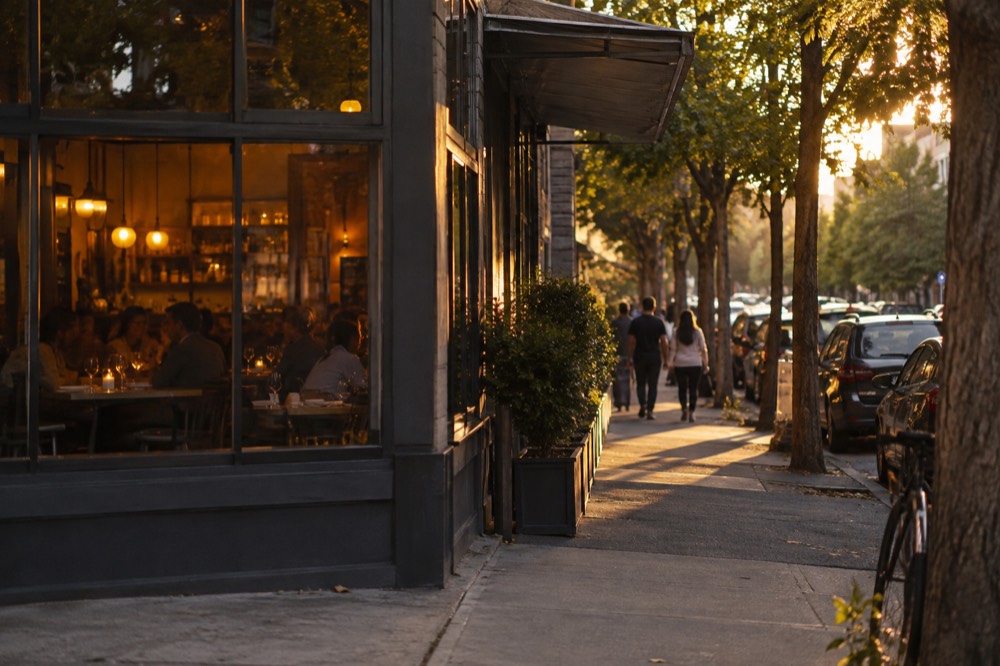 A well-lit Surry Hills street at dusk with diners visible through restaurant windows