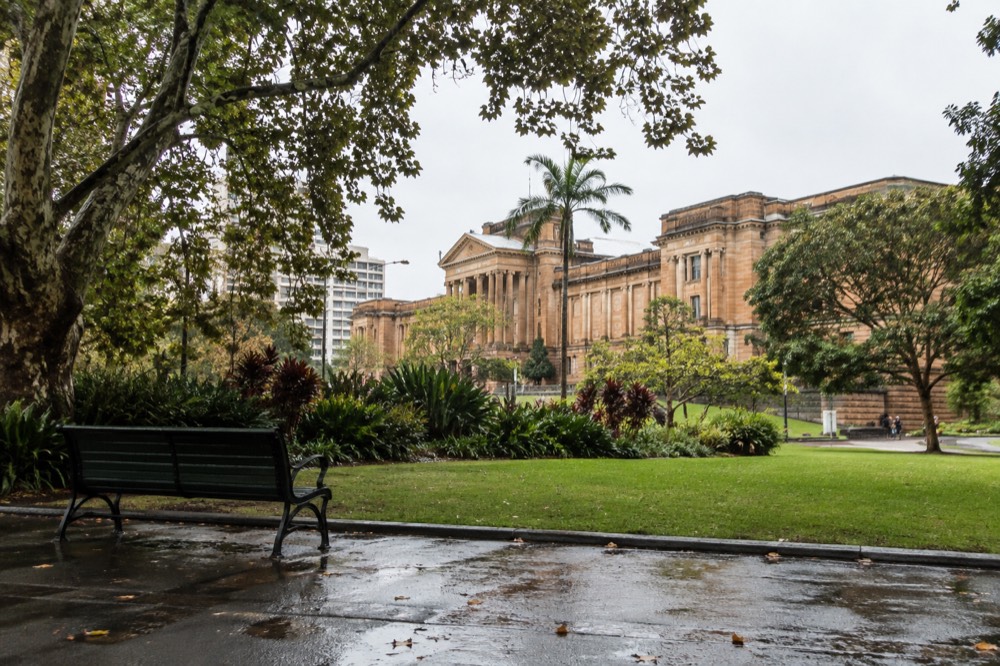 The sandstone facade of the Australian Museum seen from across Hyde Park