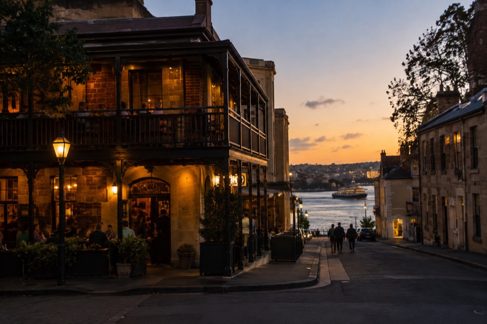 Warm evening light on a historic corner pub with timber verandahs in The Rocks