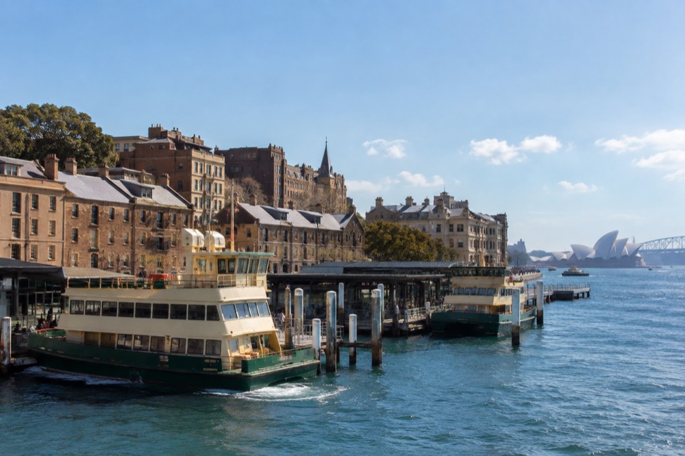 Ferry terminal at Circular Quay with ferries moored and historic buildings of The Rocks behind