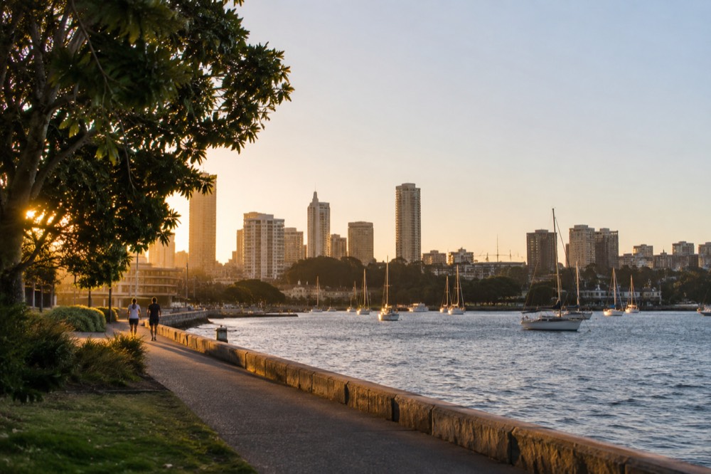 Foreshore walking path beside the water with city buildings behind