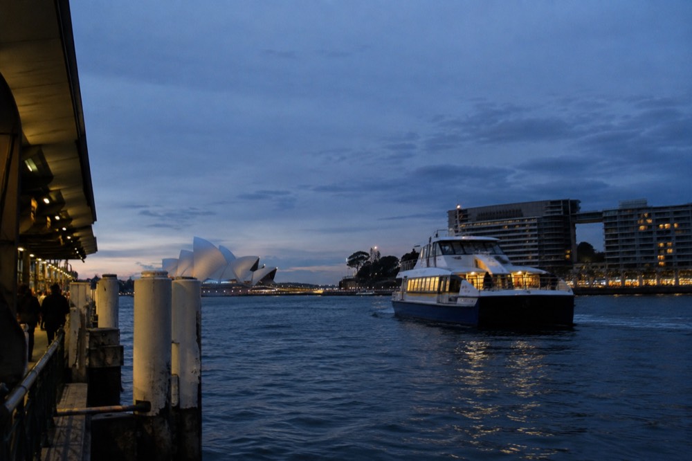 Sightseeing boat on the harbour passing wharf buildings