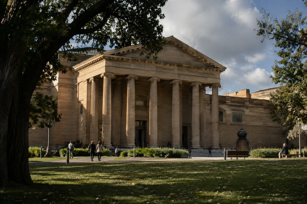 Grand gallery interior with high ceilings and paintings hung along the walls