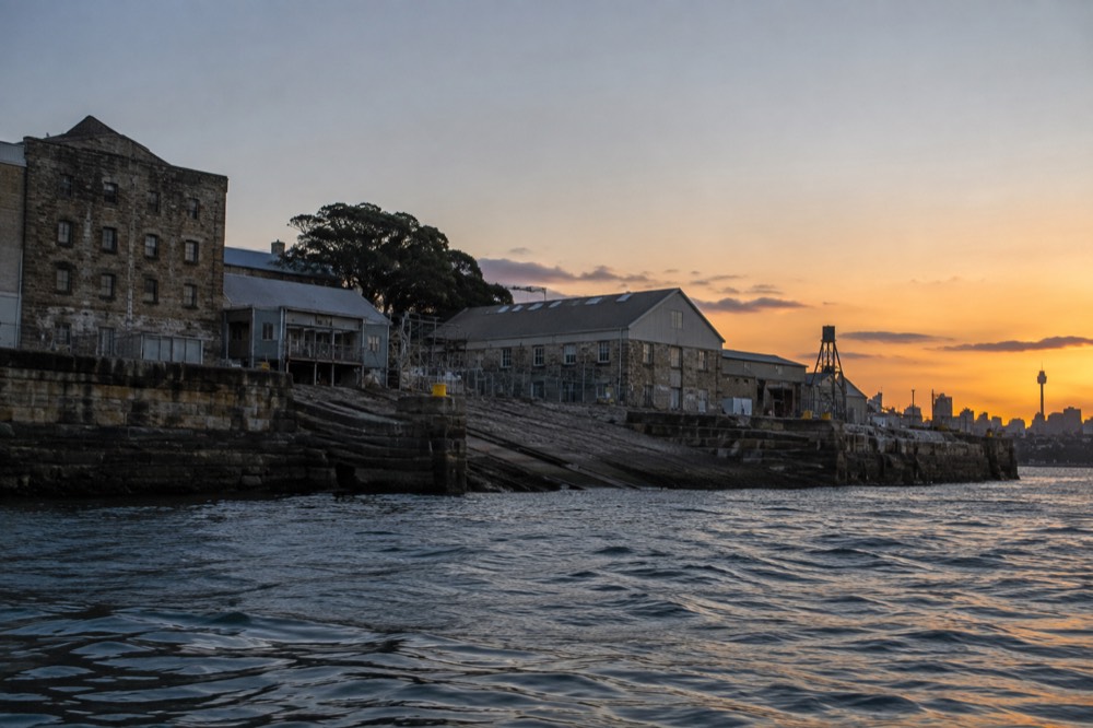 Convict-built sandstone buildings and slipway on Cockatoo Island with harbour water in the foreground