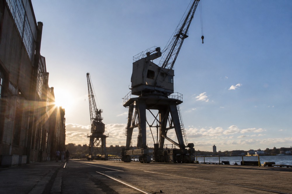Industrial cranes and dockyard machinery preserved on the island against a blue sky