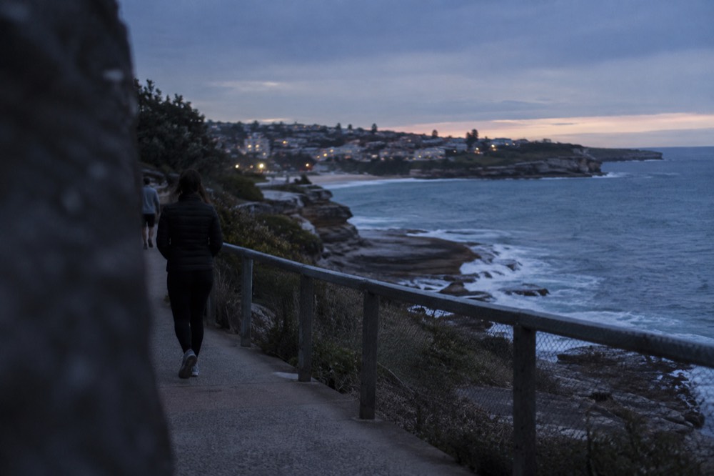 Paved clifftop path curving along sandstone headlands above the ocean