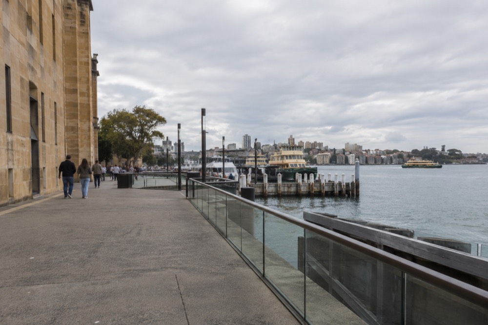 Sandstone gallery building on a harbour edge with moored ferries