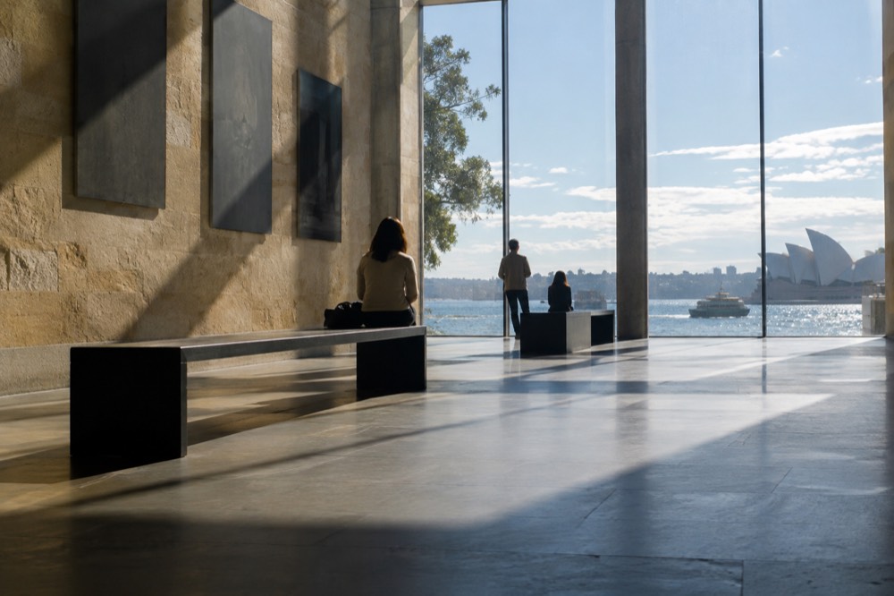 Gallery foyer with stone walls and harbour light through tall windows