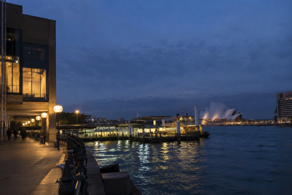 Harbour cove at dusk with lit ferry terminals and moored vessels