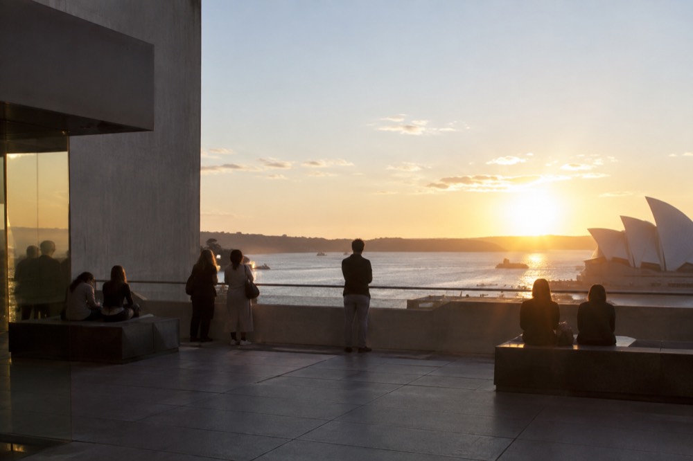 Gallery rooftop terrace overlooking a harbour at golden hour