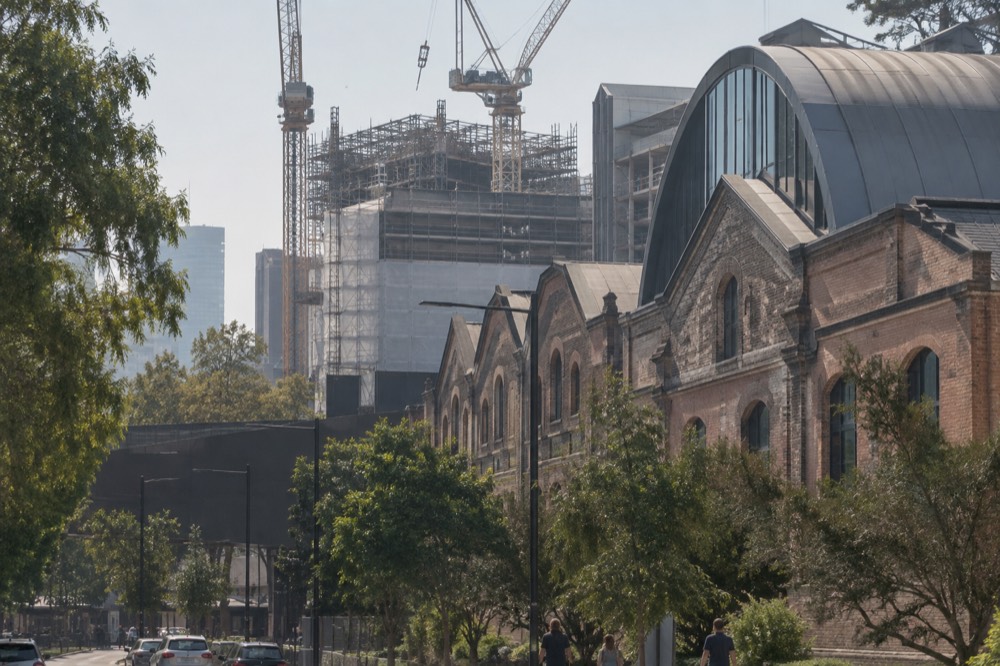 Scaffolding and cranes above a heritage brick building on a city street