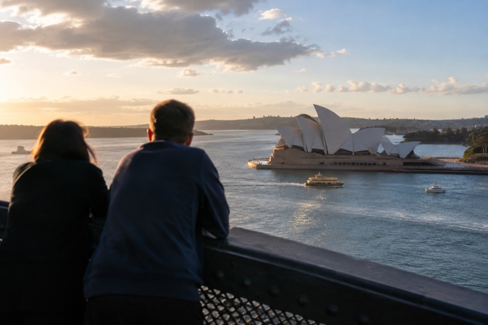 Golden late afternoon light on the Sydney Opera House and harbour seen from an elevated position near the bridge